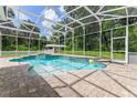 Inviting pool with a relaxing spa, surrounded by a screened enclosure and brick pavers, perfect for outdoor enjoyment at 2360 Mooneyham Dr, New Smyrna Beach, FL 32168