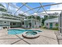 Tranquil backyard oasis featuring a pool with spa, covered patio, and well-maintained landscaping, ideal for relaxation at 2360 Mooneyham Dr, New Smyrna Beach, FL 32168