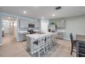 Modern kitchen with gray cabinets, stainless steel appliances, a center island with seating, and neutral tile flooring at 2731 Neverland Dr, New Smyrna Beach, FL 32168