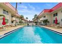 Community pool with lounge chairs and umbrellas surrounded by meticulously landscaped grounds at 2901 N Halifax Ave # 215, Daytona Beach, FL 32118