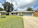 Inviting single-story home with a lush lawn, attached garage, and a cozy front porch at 2918 Mango Tree Dr, Edgewater, FL 32141