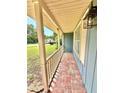 Charming front porch with brick flooring, wood supports, and a view of the neighborhood street at 2918 Mango Tree Dr, Edgewater, FL 32141