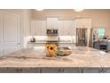 Modern kitchen features stainless steel appliances, white cabinetry, granite countertops, and a large center island at 3027 Portofino Blvd, New Smyrna Beach, FL 32168