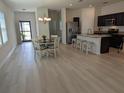 Bright dining area featuring light wood floors, a stylish chandelier, and views into the kitchen at 3103 Nova Scotia Way, New Smyrna Beach, FL 32168
