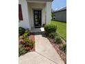 Inviting front door with colorful landscaping, leading to a welcoming home entrance at 3103 Nova Scotia Way, New Smyrna Beach, FL 32168