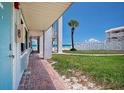 Exterior of a teal door condo with a palm tree and beach view at 3509 S Atlantic Ave # 109, New Smyrna Beach, FL 32169