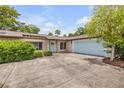 Charming single-story home with a well-maintained lawn, a light blue door and a two car garage at 357 Hearthstone Ter, Port Orange, FL 32127