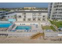 An exterior aerial of a condo building with a beach access, and a pool at 3615 S Atlantic Ave # 211, Daytona Beach, FL 32118