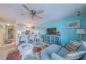 Living room area with aqua blue wall, open to bar style seating and kitchen at 3615 S Atlantic Ave # 211, Daytona Beach, FL 32118