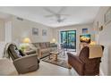 Inviting living room with cozy seating, ceiling fan, TV, and sliding glass doors to the outside at 4403 Sea Mist Dr # 109, New Smyrna Beach, FL 32169