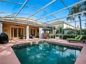 Inviting screened-in pool area with lounge chairs, patio furniture, and clear views of the blue sky above at 461 Luna Bella Ln, New Smyrna Beach, FL 32168