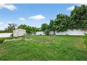 Spacious backyard featuring a well-maintained lawn, a shed, and bordered by a white vinyl fence for privacy at 505 Sandale Ct, Deland, FL 32724