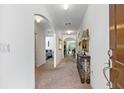 Inviting hallway with elegant archways, neutral carpet, and decorative console table, leading to various rooms at 518 Safe Harbor Dr, Edgewater, FL 32141