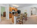 Functional kitchen featuring a central island with seating, wooden cabinetry, and essential appliances under bright lighting at 518 Safe Harbor Dr, Edgewater, FL 32141
