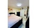 Comfortable bedroom featuring a black bed frame, closet, and light yellow walls at 520 Aeolian Dr, New Smyrna Beach, FL 32168