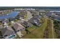 Aerial view of a home with a backyard pool in a community with a pond, and well-maintained landscaping at 5263 Bear Corn Run, Port Orange, FL 32128