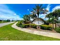 A landscaped stone monument marks the entrance to Hawks Preserve under a sunny sky filled with fluffy clouds at 5263 Bear Corn Run, Port Orange, FL 32128