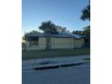 View of charming yellow single-story home surrounded by chain link fence and mature tree at 585 Washington St, New Smyrna Beach, FL 32168