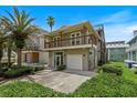 Two-story home featuring a balcony, a garage, and a well-manicured front yard with verdant landscaping at 6956 Turtlemound Rd, New Smyrna Beach, FL 32169