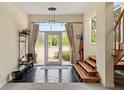 Bright foyer with tile flooring, a coat rack, and stairs leading to upper levels and natural light at 6956 Turtlemound Rd, New Smyrna Beach, FL 32169