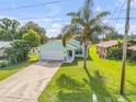 Charming single Gathering home featuring an attached two car garage, well maintained lawn, and lush tropical landscaping at 805 Spruce St, New Smyrna Beach, FL 32168
