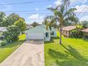 Charming single Gathering home featuring an attached two car garage, well maintained lawn, and lush tropical landscaping at 805 Spruce St, New Smyrna Beach, FL 32168