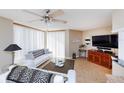 Inviting living room with modern ceiling fan, comfortable seating, and sliding doors for natural light and access at 1 Oceans West Blvd # 1B5, Daytona Beach, FL 32118