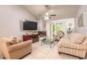 Bright living room with a cozy fireplace, tile flooring, and access to the outdoor space at 1237 Charter Oaks Cir, Daytona Beach, FL 32117