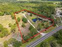 Expansive property with mature trees, a large pond, and a long driveway at 156 S State Road 415, New Smyrna Beach, FL 32168