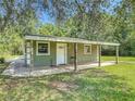 Guest house with a covered porch and a well-maintained lawn at 156 S State Road 415, New Smyrna Beach, FL 32168