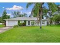 Inviting single-story white home with lush green lawn and beautiful landscaping at 1903 Willow Oak Dr, Edgewater, FL 32141