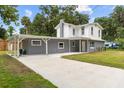 Gray and white two-story home with a carport and freshly sealed driveway at 2005 Sunny Ln, New Smyrna Beach, FL 32168