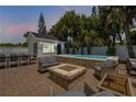 Inviting backyard patio with a spa, fire pit, comfortable seating, and outdoor dining area at 206 Kirkland Rd, New Smyrna Beach, FL 32169