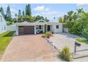 Charming single-story home featuring a modern garage door, brick driveway, and low maintenance landscaping at 206 Kirkland Rd, New Smyrna Beach, FL 32169