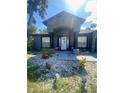Close-up front entrance featuring a decorative rock garden and seating area at 2122 Orange Tree Dr, Edgewater, FL 32141