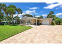 Inviting exterior of a well-maintained single-story home with a manicured lawn and beautiful stone accents at 22 Sand Dune Dr, New Smyrna Beach, FL 32169