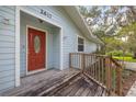 Inviting front porch with wood deck and red front door, perfect for relaxing at 2617 Pine Tree Dr, Edgewater, FL 32141