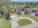 Aerial view of a two-story home with palms, circular driveway, garage, and a glimpse of the serene neighborhood at 2715 Pine Tree Dr, Edgewater, FL 32141