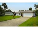 A single-story home featuring an expansive driveway and a two-car garage at 2944 Mango Tree Dr, Edgewater, FL 32141