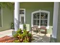 Inviting front porch with seating area framed by elegant columns and a beautifully arched window at 3288 Spruce Creek Gln, Port Orange, FL 32128