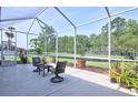 Relaxing screened-in patio offers scenic views of a lush backyard and tranquil pond at 3288 Spruce Creek Gln, Port Orange, FL 32128