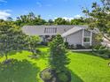 Beautifully landscaped front yard with lush green lawn and mature trees enhancing the curb appeal at 343 Sweet Bay Ave, New Smyrna Beach, FL 32168