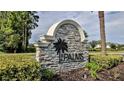 Elegant stone entrance sign with a palm tree emblem marking the community's name at 349 Caryota Ct, New Smyrna Beach, FL 32168