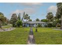Inviting single-story home with a lush front yard and walkway, perfect for a relaxed lifestyle at 38 Fairway Cir, New Smyrna Beach, FL 32168