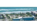 Breathtaking aerial view showcasing the oceanfront property, pristine beach, community parks, and surrounding buildings at 3824 Saxon Dr, New Smyrna Beach, FL 32169