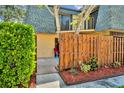 Inviting townhouse entrance with a private fenced-in patio and vibrant landscaping at 3824 Saxon Dr, New Smyrna Beach, FL 32169