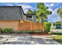 Two-story townhouse showcasing a private wooden fence, neutral brickwork, and ample parking space at 3824 Saxon Dr, New Smyrna Beach, FL 32169
