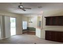 Open-concept living area featuring neutral carpet, ceiling fan, natural light, and sliding glass doors leading to outdoor space at 405 Central Mariners Dr, Edgewater, FL 32141