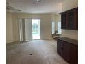 Bright living room with neutral carpet and built-in cabinetry with views of the screened-in pool area at 405 Central Mariners Dr, Edgewater, FL 32141