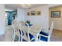 Bright dining area with seating for six opens to kitchen with beautiful blue cabinetry at 4175 S Atlantic Ave # 4110, New Smyrna Beach, FL 32169